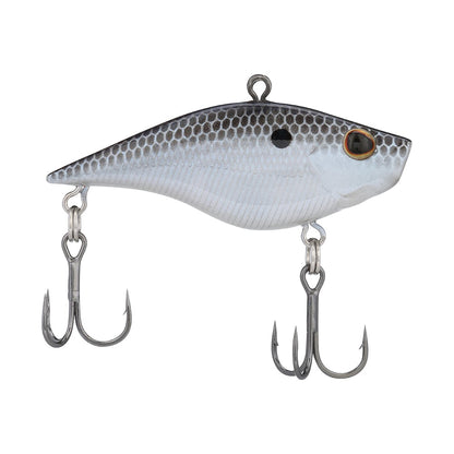 The Berkley Warpig Jr. Lipless Crankbait by Berkley is a realistic fish-shaped, silver-bodied sinking bait with black scales. It boasts an aggressive action, loud sound, two treble hooks on the belly and tail, and a single eye with a dark pupil.