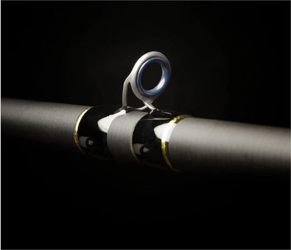 Close-up of a Falcon Cara Casting Rod Amistad 7'3" Heavy (CC-7-173) guide ring, featuring a metallic frame and dark glossy wrapping, set against a black background.