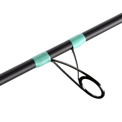 Close-up of a G. Loomis GCX Inshore Spinning Rod 902S XF 7'6" Medium (12979-01) featuring a green accent near a metal guide ring, perfect for saltwater angling.