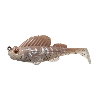 The Megabass Dark Sleeper Swimbait by Megabass is a soft plastic lure shaped like a small fish, featuring a translucent beige color with dark speckles, a large dorsal fin, paddle-tail action, and a metal loop for your fishing line.