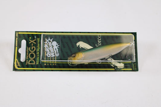 The Megabass Dog-X Quick Walker pencil bait, featuring a lifelike yellow-silver fish pattern on green and black packaging with white and gold text, tempts anglers with its unique one-knock sound.