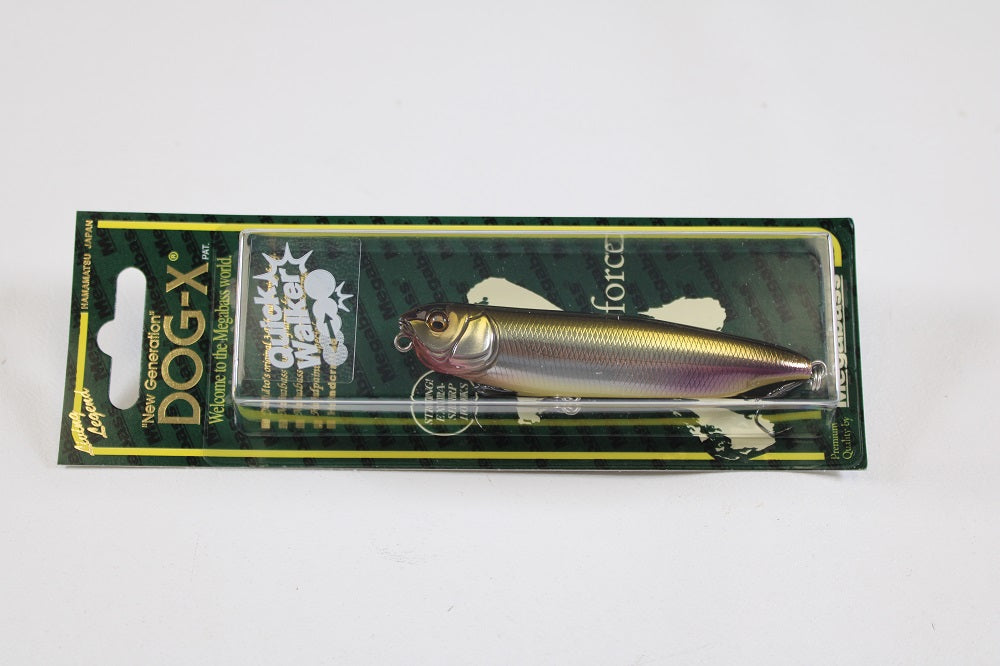 A packaged Megabass Dog-X Quick Walker fishing lure features a silver, dark-shaded lifelike fish design with a detailed face and enticing one-knock sound, displayed on a green and black card labeled "Quiker Waker Wild.