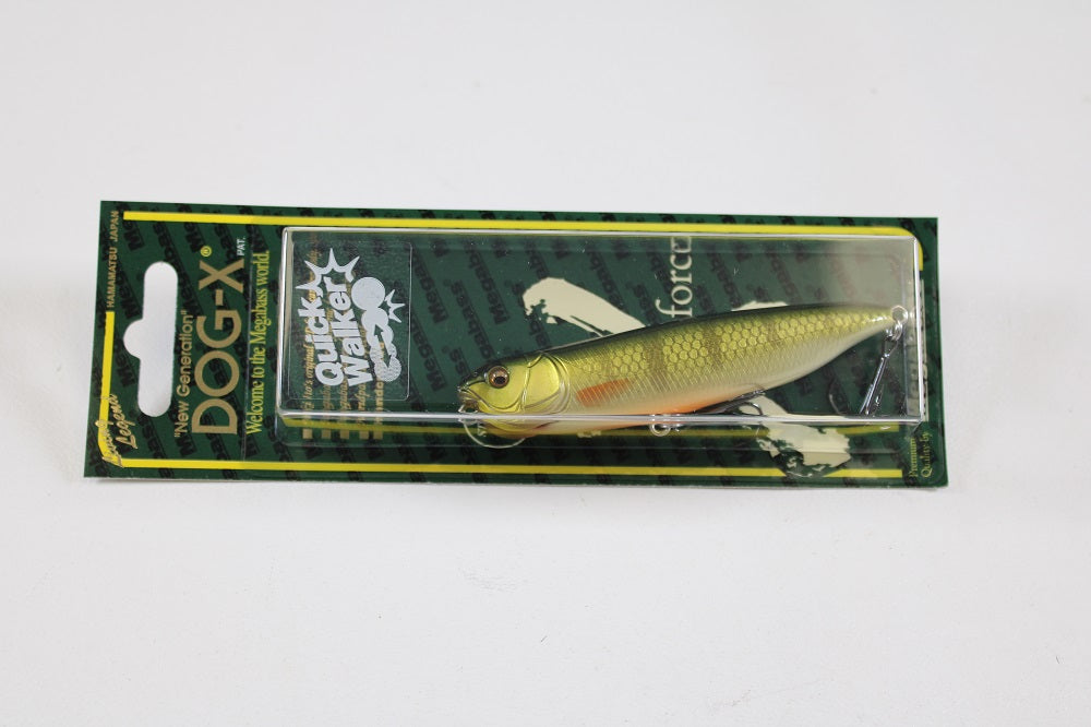 A packaged Megabass Dog-X Quick Walker pencil bait with a green-yellow fish design and "Quick Walker" on the front, known for its unique one-knock sound, comes in a clear plastic case with black and green backing.