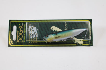 A packaged Megabass Dog-X Quick Walker pencil bait fishing lure with a blue, yellow, and silver fish design and one-knock sound, displayed on a black and green card with Megabass branding and product info.