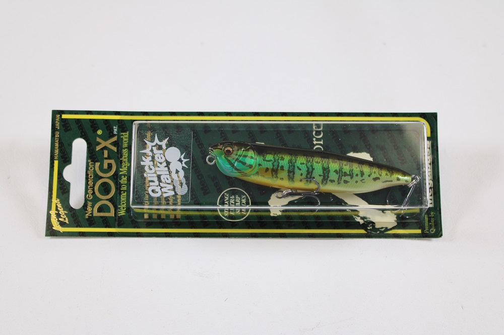 A packaged Megabass Dog-X Quick Walker pencil bait in green and black is shown against a white background, with the packaging highlighting features like "one-knock sound," quick walking action, and Megabass branding.