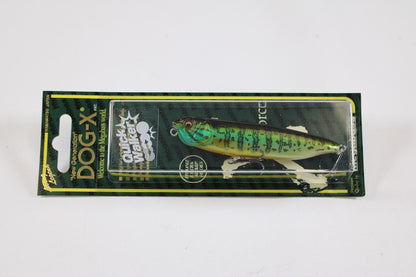 A packaged Megabass Dog-X Quick Walker pencil bait in green and black is shown against a white background, with the packaging highlighting features like "one-knock sound," quick walking action, and Megabass branding.