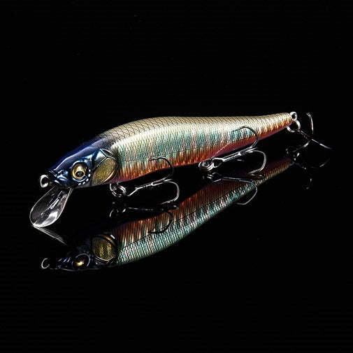The Megabass ITO Vision 110+1 (SP-C) Magome Oikawa lure, featuring a silver belly, blue back, orange sides, and three treble hooks, is displayed against a black background. Brand: Megabass.
