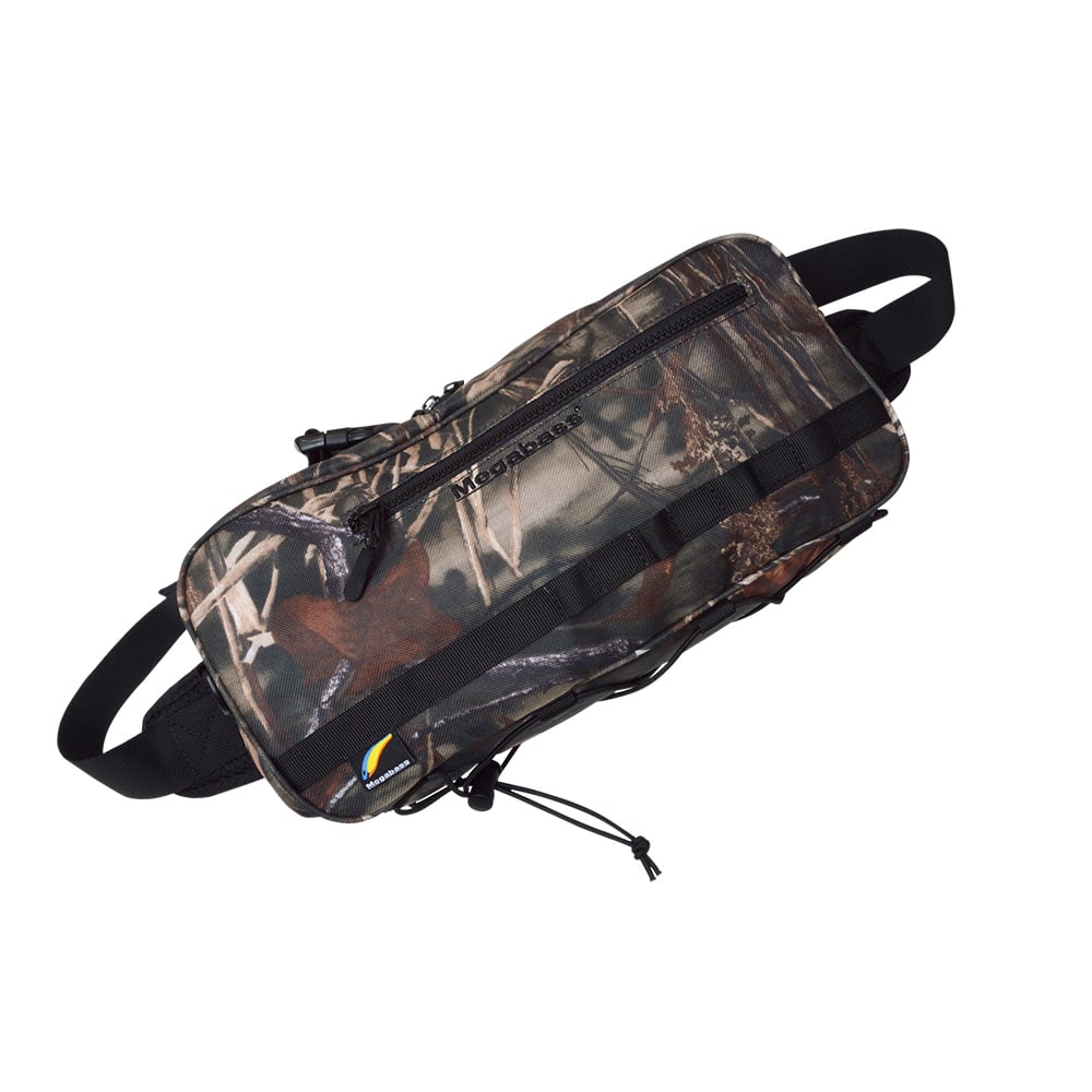The Megabass Rapid Bag Real Camo | 0426234979 features a camouflage pattern, multiple zippered compartments, and black adjustable straps. Its rugged design and large capacity are ideal for carrying essentials during shore fishing adventures.