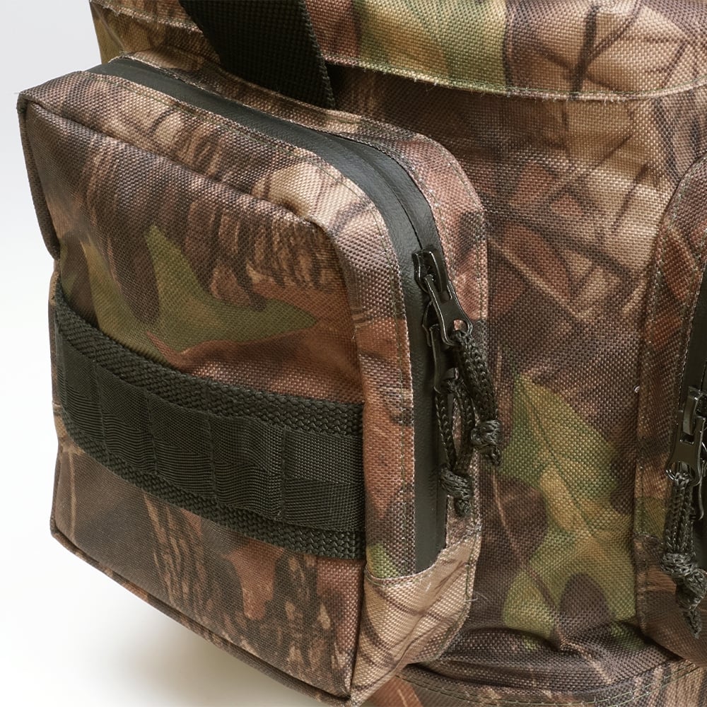 Close-up of the Megabass Survival Bag II by Megabass, featuring a camouflage pattern in brown, green, and tan with a front zippered pocket and webbing for a military-inspired tackle bag with forest-themed style.