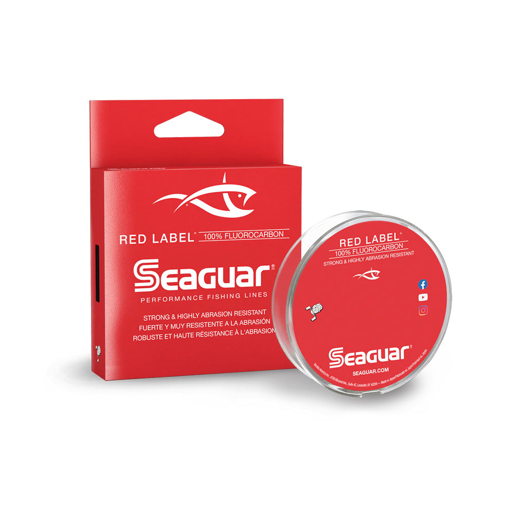 The Seaguar Red Label Fluorocarbon Line, by Seaguar, comes in a red box with a clear spool. The packaging emphasizes its "strong & highly abrasion resistant" features in English and French.