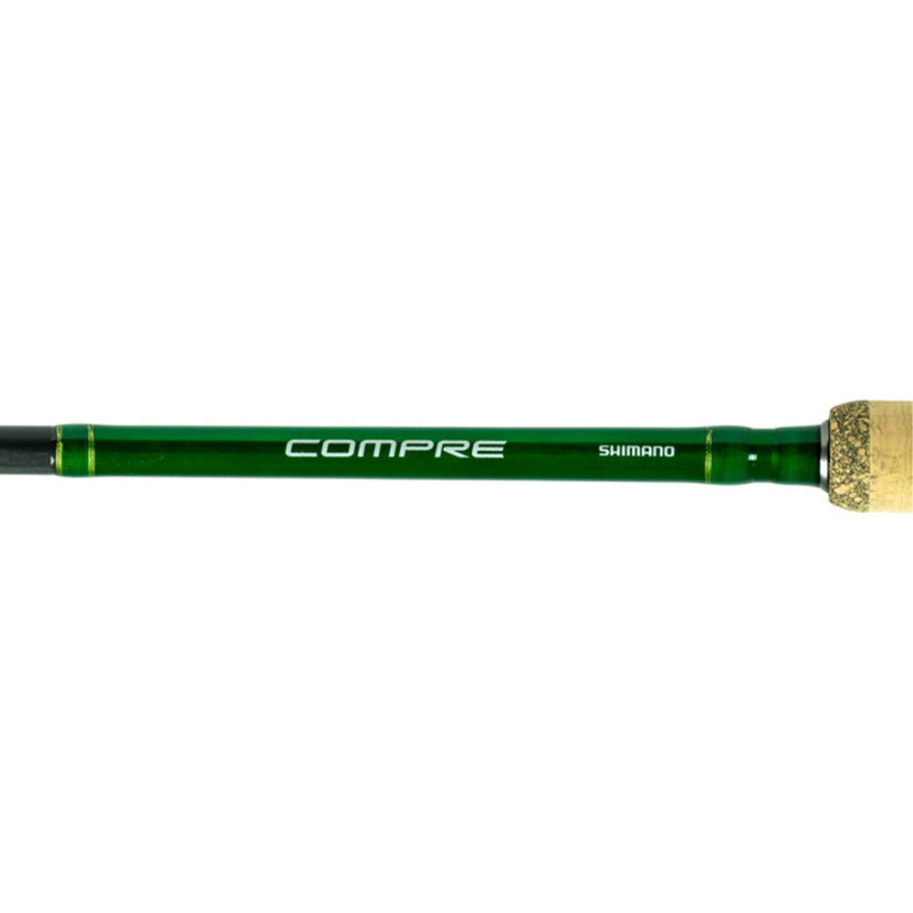 A close-up of the Shimano Compre Muskie Casting Rod 8'0" Heavy (CPCM80HJ) handle with cork grip, featuring "COMPRE" and "SHIMANO" logos in white—a quality heavy action rod for muskie casting.