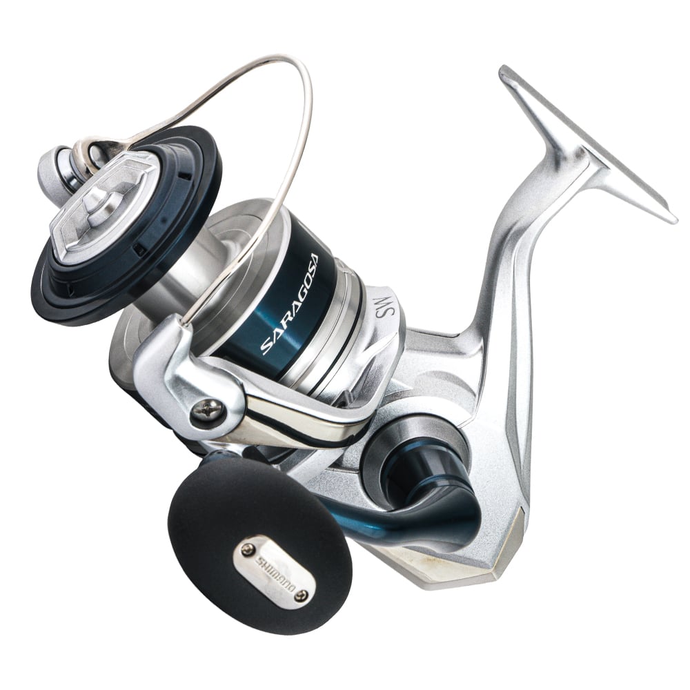 The Shimano Saragosa Spinning Reel 10000SWAPG 4.9:1 features a sleek silver and black design ideal for saltwater fishing, with a circular spool, black-gripped handle, and "SARAGOSA" displayed on the side.