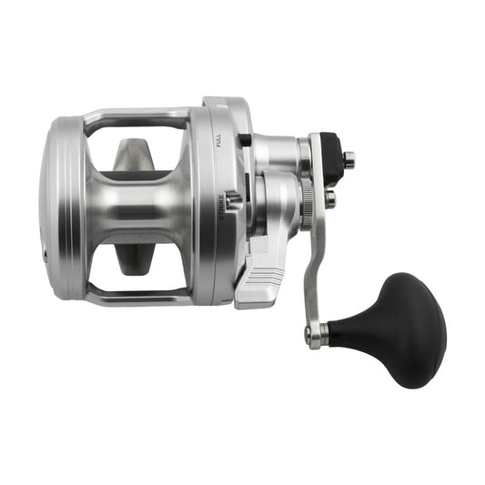 The Shimano SpeedMaster 20II 5.2:1/2.3:1 SPM20II, a silver conventional reel with large handle and black grip, features a durable HAGANE Body and is shown from the side against a white background.