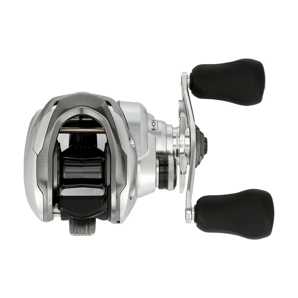 The Shimano Tranx 150A Casting Reel 7.2:1 Left Hand (TRX151HGA) features a silver and black design with two large black rubber handle grips, ideal for saltwater fishing. Brand: Shimano. Shown against a white background.