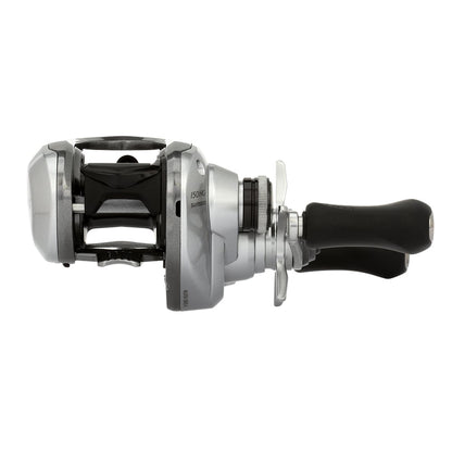 The Shimano Tranx 150A Casting Reel 7.2:1 Right Hand (TRX150HGA) features a sleek silver and black design with ergonomic grips and adjustable knobs, ideal for saltwater fishing. Brand: Shimano.