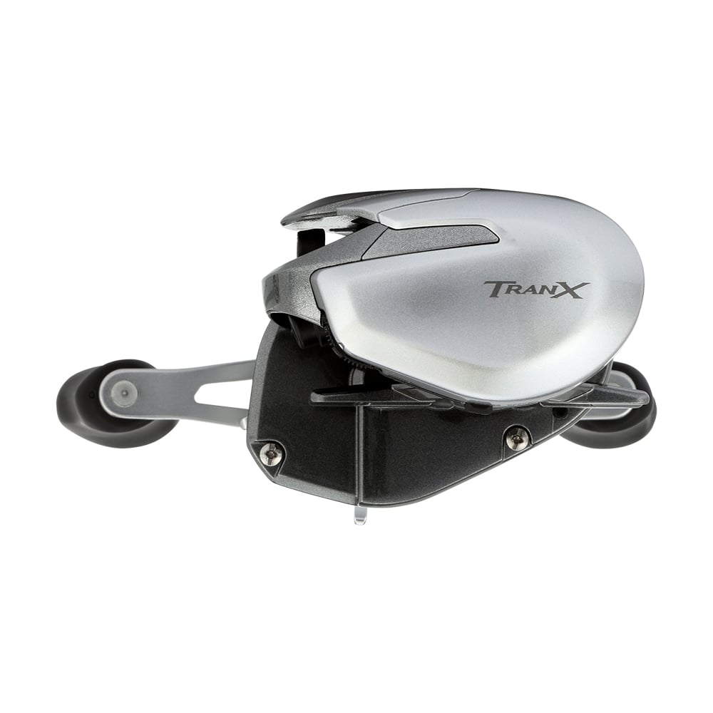 The Shimano Tranx 150A Casting Reel 8.2:1 Right Hand (TRX150XGA) features a silver and black, compact design with dual handles—ideal for saltwater fishing. Seen from an angled side view, this Shimano reel blends style and performance.