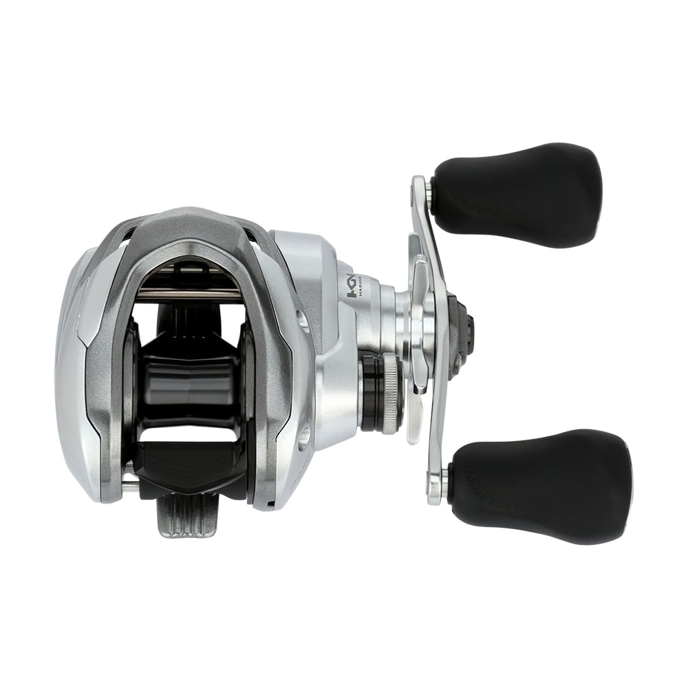 The Shimano Tranx 150A Casting Reel 8.2:1 Right Hand (TRX150XGA) by Shimano features a sleek silver and black look with dual black handles—perfect for precision saltwater fishing.