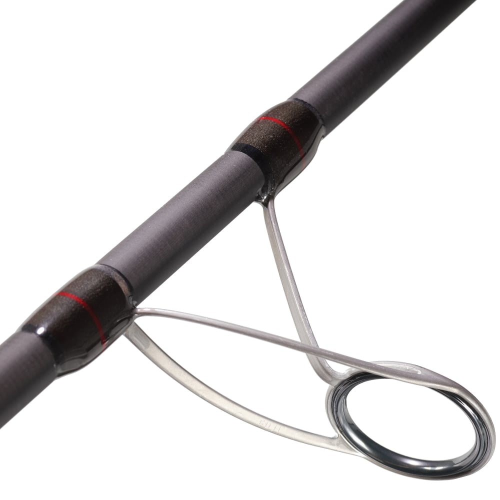 A close-up showcases the sleek design of a surf rod guide on the SCIII carbon St. Croix Avid Surf Spinning Rod 10’0” Medium | VSS100MF2 by americanlegacyfishing, featuring a metal ring and support structure with red accents contrasting its dark background, optimized for maximum casting distance.