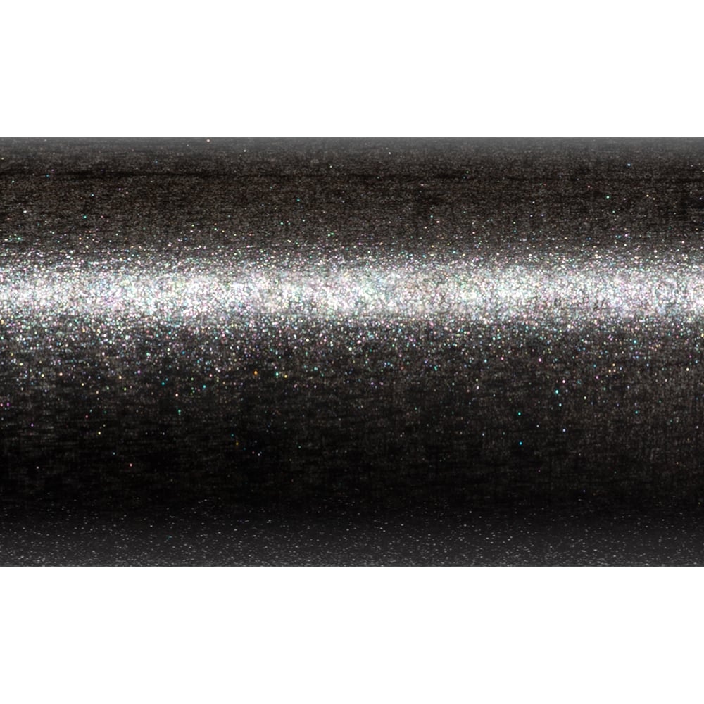 A close-up of the St. Croix Avid Trek Travel Spinning Rod 7'0” Medium Heavy shows its dark SCIII carbon body with a metallic, glittery surface that reflects light and shimmers with colorful specks.
