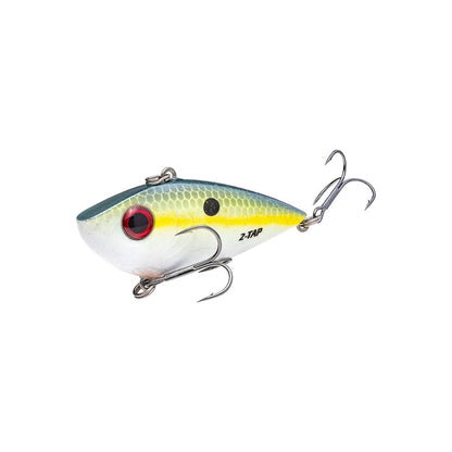 The Strike King Red Eye Shad Tungsten 2 Tap lure features a fish-like shape, a silver body with a yellow stripe, and a red eye. This lipless crankbait includes two treble hooks: one on the underside and another at the tail.