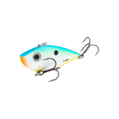 The Strike King Red Eye Shad Tungsten 2 Tap is a dynamic lipless crankbait with a blue-to-yellow gradient and scale-like texture. It features two treble hooks, a black eye dot, and "Z-Tap" lettering, resembling the Strike King Red Eye Shad design.