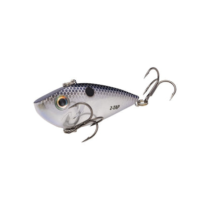 The Strike King Red Eye Shad Tungsten 2 Tap features a silver and blue fish shape with yellow and black eyes, two sharp treble hooks, and a textured body mimicking scales, making it the perfect lipless crankbait for anglers.