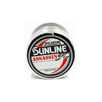 The Sunline Assassin FC Fluorocarbon Line, labeled "Best Casting 100% Fluorocarbon Line, Made in Japan," features Pion Technology for superior abrasion resistance. Its black and red text stands out on a crisp white background.