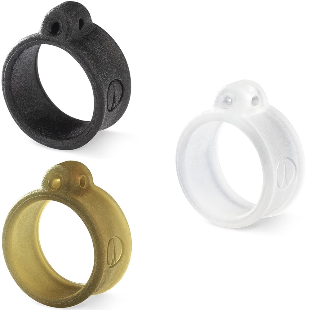 Three round, textured VMC Crossover Rings by VMC, ideal for Neko rigging, are displayed on a white background. The rings come in black, gold, and clear, each featuring a small protrusion and an embossed logo.