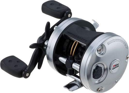 The Abu Garcia Ambassadeur C3 5.3:1 Casting Reel 5500, in silver and black with a crank handle and thumb bar, is displayed at an angle on a white background, showcasing its Carbon Matrix drag system.
