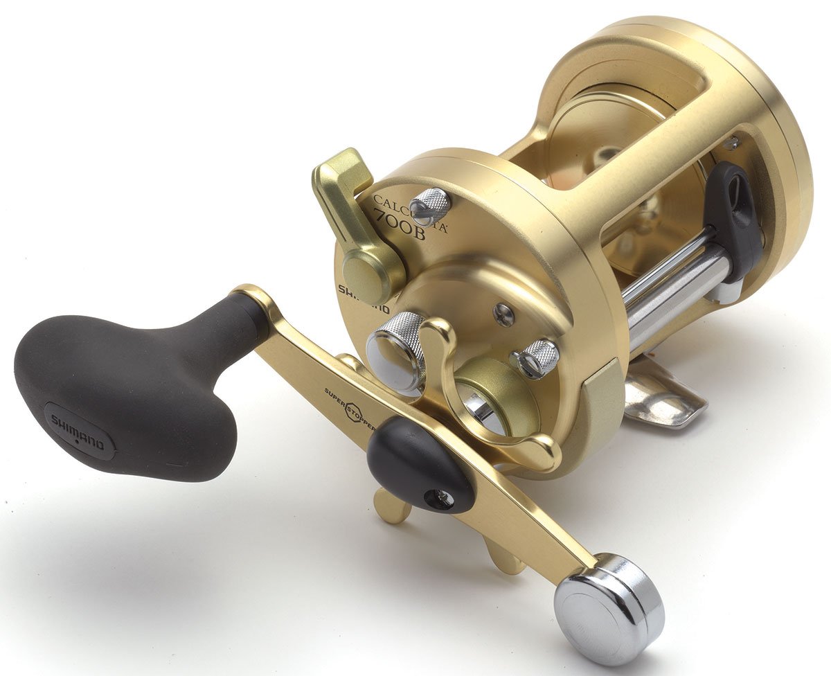 A Shimano Calcutta B 4.7:1 Round Casting Reel CT700B in gold with a black handle, Dartanium Drag, and precision metal components is displayed on a white background.
