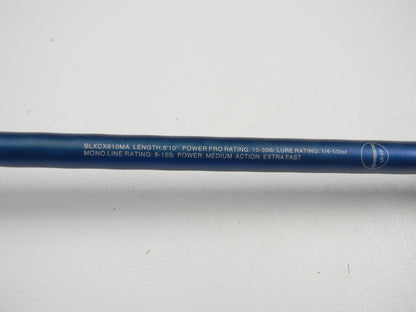 A close-up of a blue Shimano SLX SLXCX610MA 6'10" Medium used casting rod in excellent condition, showing white specs text. Ideal for those seeking used Shimano gear or a rod and reel trade-in. The rod rests on a white surface.