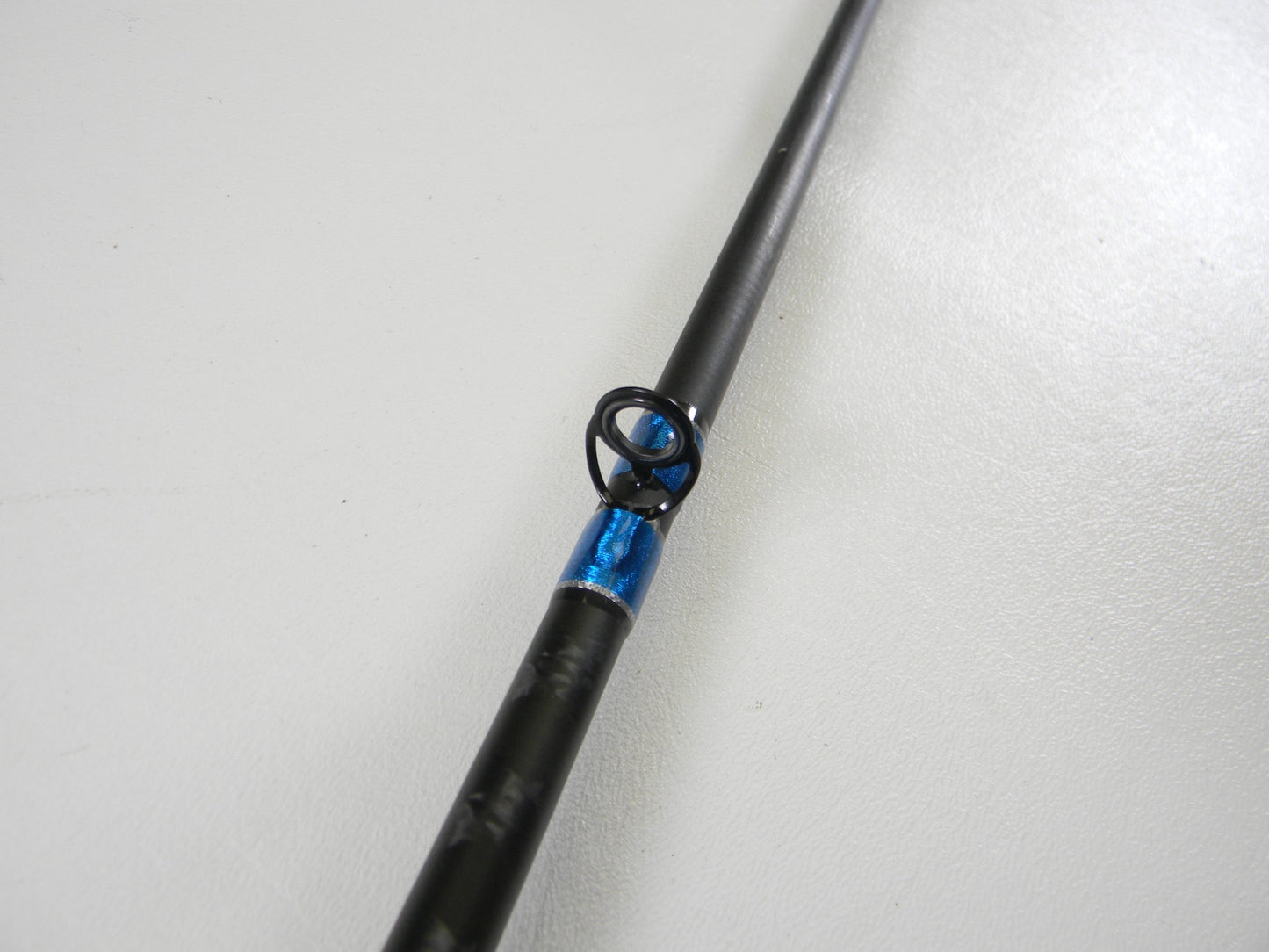 Close-up of a Shimano SLX SLXCX610MA 6'10" Medium casting rod in excellent used condition, featuring a blue-wrapped guide—ideal for those shopping used gear or interested in our rod and reel trade-in.