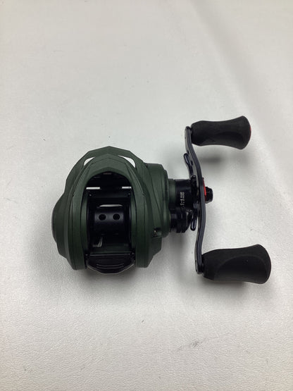 An Abu Garcia Zata 7.1:1 right-hand baitcasting reel in excellent used condition, featuring a green body, black handles, and a compact design, is displayed on a white surface.