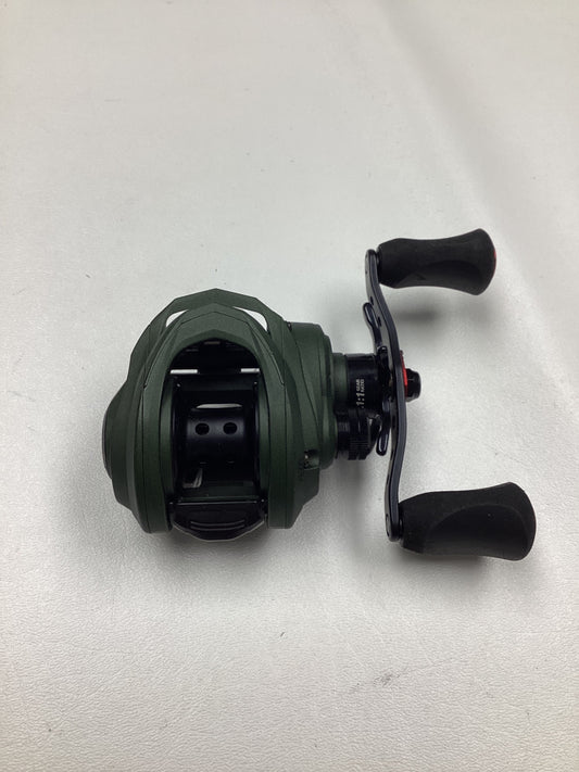 An Abu Garcia Zata 7.1:1 right-hand baitcasting reel in excellent used condition, featuring a green body, black handles, and a compact design, is displayed on a white surface.