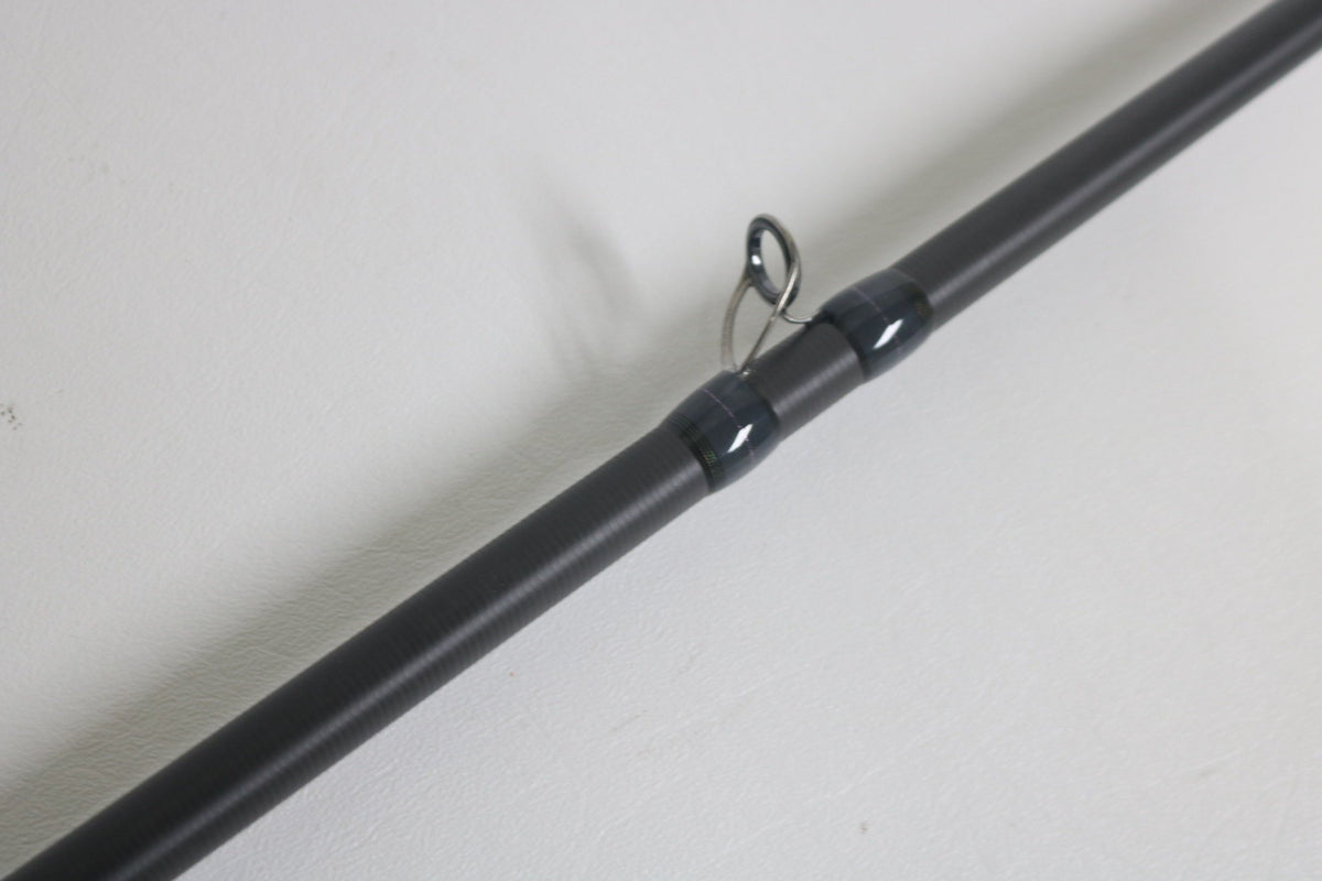 Close-up of a Megabass Destroyer P5 F7.1/2-76X Used Casting Rod in excellent condition, highlighting one of its black line guides against a plain white background.