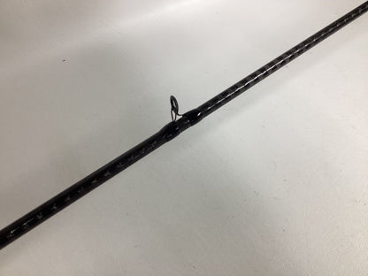 Close-up of a Shimano Zodias ZDC610MHA black fishing rod on a white background, featuring a line guide ring at the center, textured surface, and white markings. Trade it in through the Nation's Best Rod and Reel Trade-In Program for store credit.