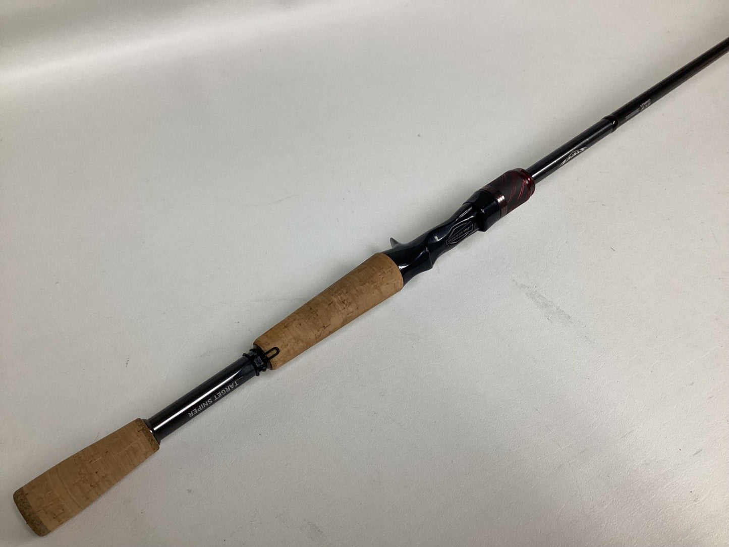 The Daiwa Steez AGS STAGS691MHFB Used Casting Rod, in excellent condition, features a modern black design with cork handles and red-accented reel seat—perfect for anglers seeking quality used gear or using our Rod and Reel Trade-In.