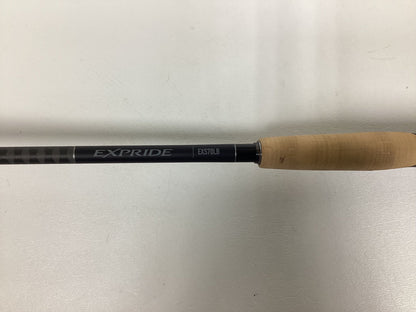 A Shimano Expride B EXS70LB spinning rod featuring a light brown grip and black shaft is displayed on a plain white background.