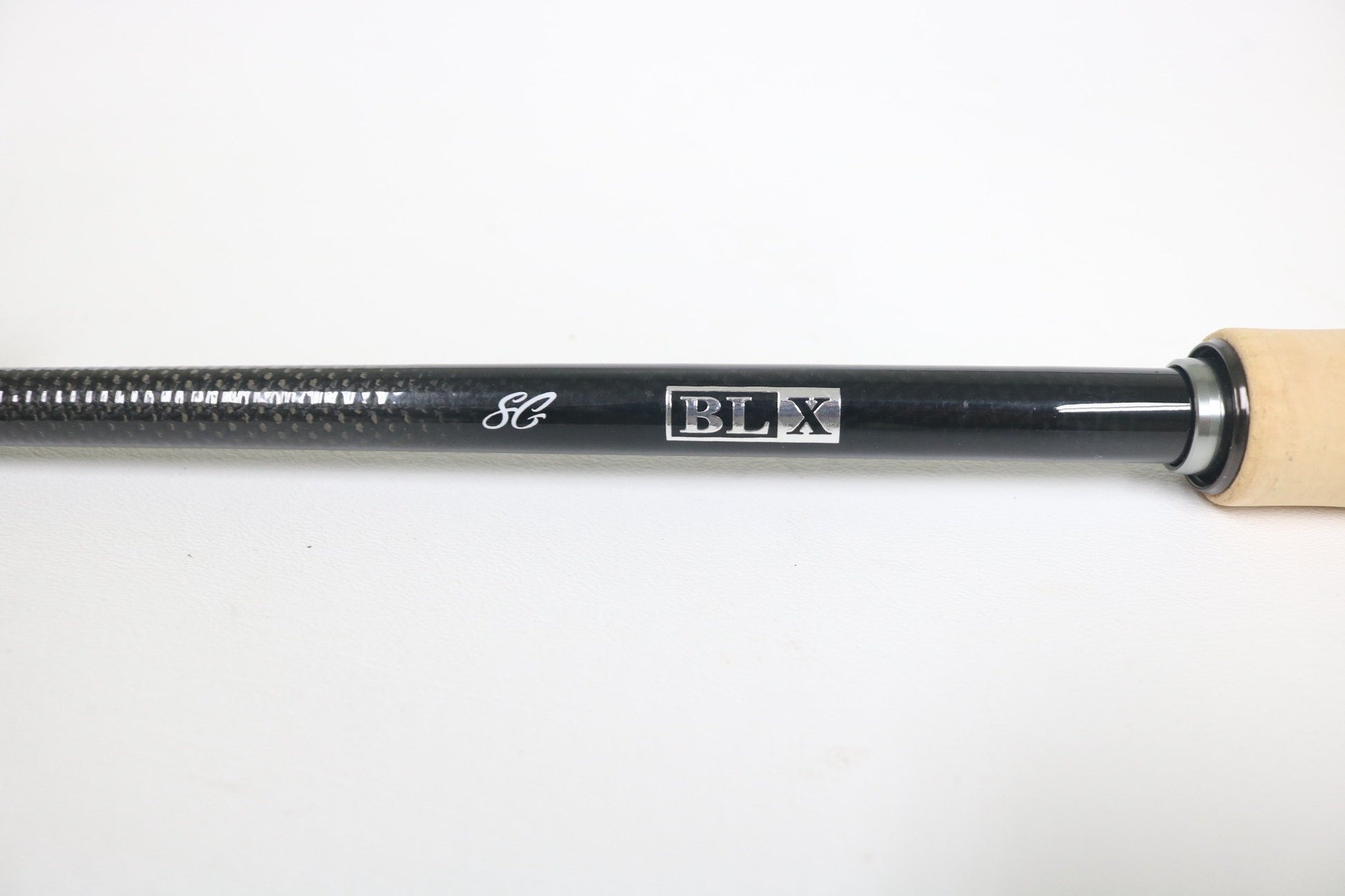 Close-up of a Daiwa BLX SG721HFB 7'2" Heavy Used Casting Rod handle in very good condition, showing its black shaft, "BLX" silver box design, white logo, and light wood grip—ideal for our Rod and Reel Trade-In Program.