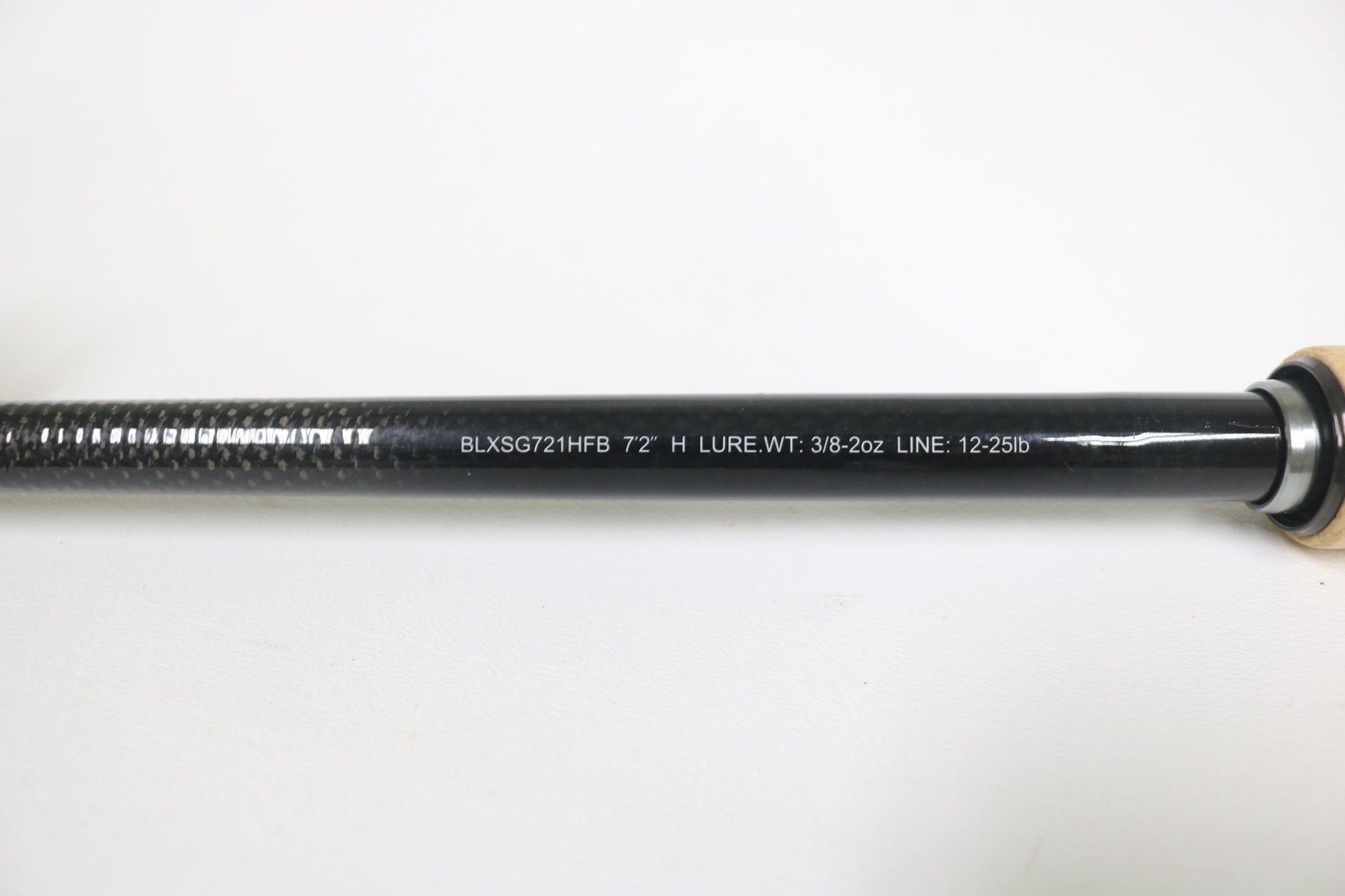 A close-up of the Daiwa BLX SG721HFB 7'2" Heavy Used Casting Rod in very good condition, featuring a textured grip, metallic ring near the handle, and white printed specs. Great for anglers or trading up through our Rod and Reel Trade-In Program.