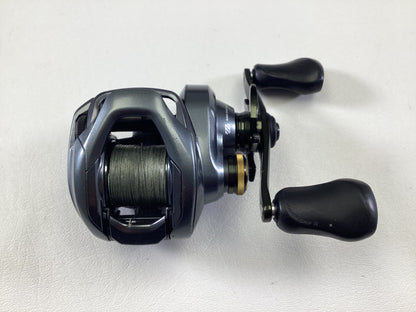 The Shimano Curado CUDC150XG Used Casting Reel, in very good condition, is displayed on a white surface. It features a metallic finish with a black handle and has its spool partially filled with green fishing line, exemplifying the quality associated with used Shimano gear.