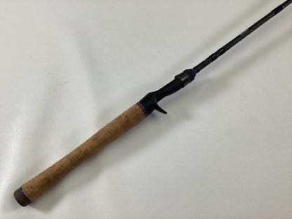 The Dobyns Champion XP DC685CB Used Casting Rod by Dobyns, in excellent condition, features a cork handle and black reel seat, displayed diagonally on a white surface.
