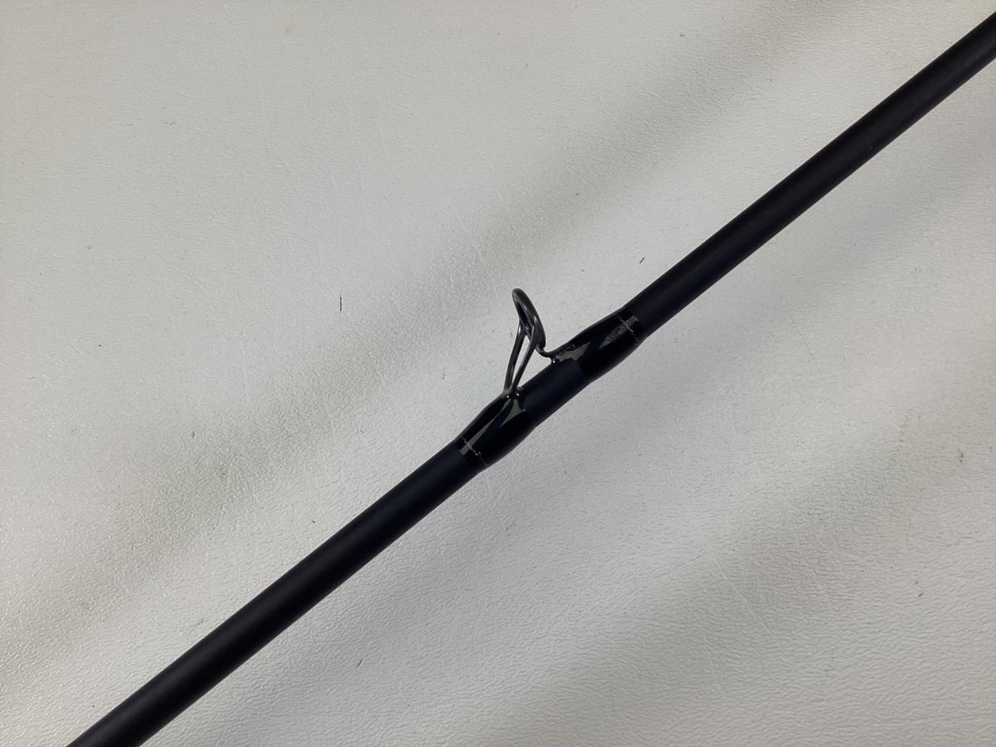 A close-up of the Dobyns Champion XP DC685CB Used Casting Rod in excellent condition, featuring a black finish and metal line guide, shown against a plain white background.