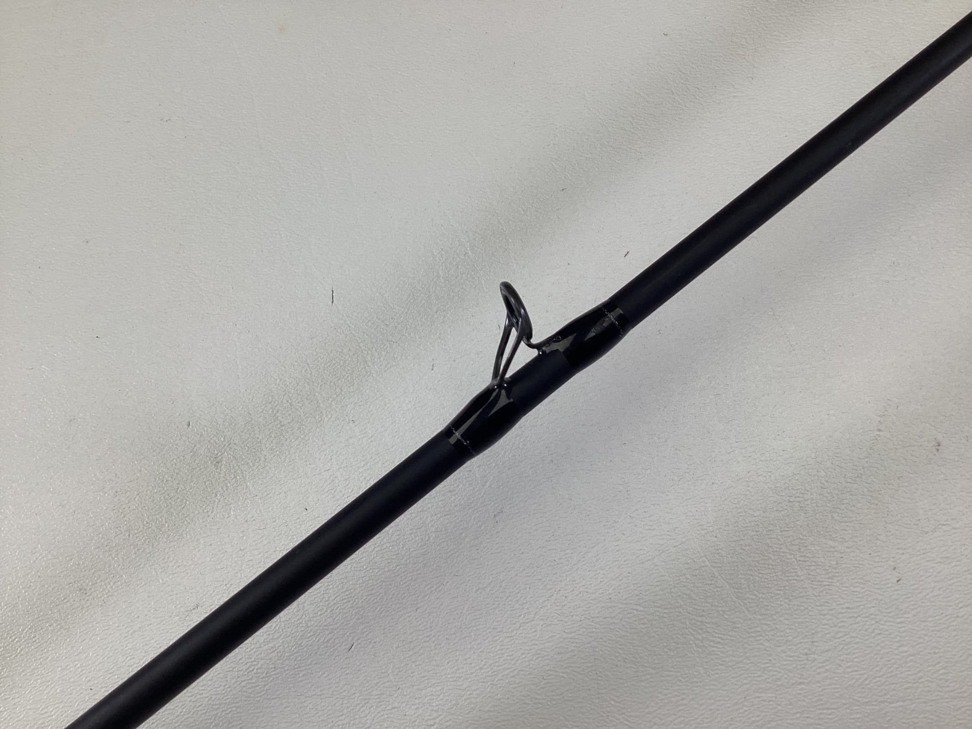 A close-up of the Dobyns Champion XP DC685CB Used Casting Rod in excellent condition, featuring a black finish and metal line guide, shown against a plain white background.