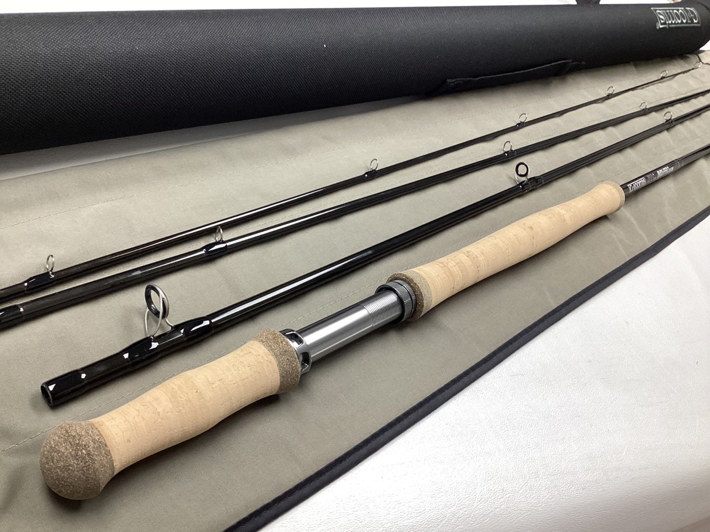The G. Loomis IMX-PRO V2 Shortspey 3111-4 11'1" #3, a mint condition used fly rod, is displayed with its black case—perfect for customers interested in our trade-in program for store credit or gently used gear.