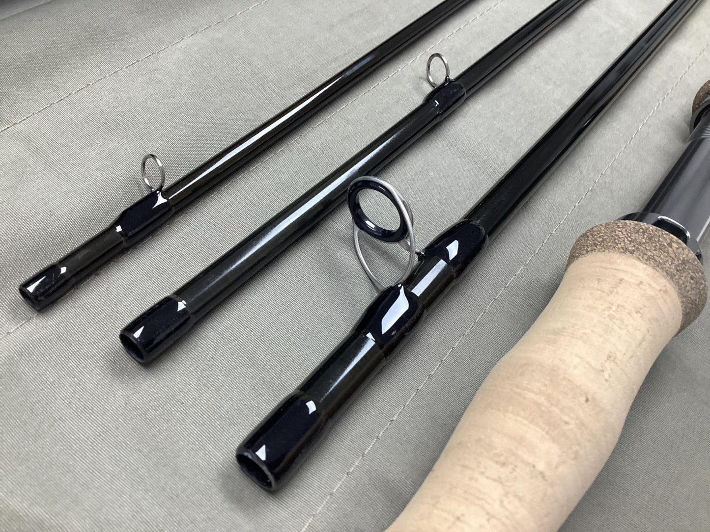 Close-up of a G. Loomis IMX-PRO V2 Shortspey 3111-4 11'1" #3 used fly rod in mint condition, featuring metal line guides and cork handle—ideal for those upgrading via our rod and reel trade-in program.