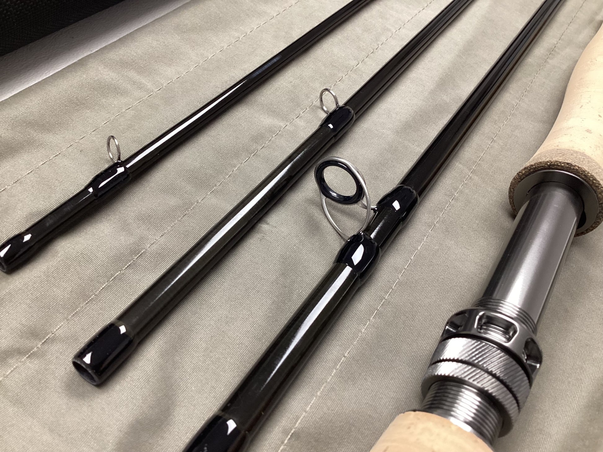 The G. Loomis IMX-PRO V2 Fly Rod 8100-4 10'0" #8, in mint used condition, features four sections with guides and a cork handle with metal reel seat—ideal for anglers or those interested in our rod and reel trade-in program.