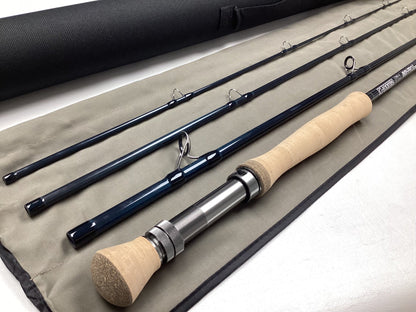 The G. Loomis IMX-PRO V2S Saltwater 1290-4 9'0" #12 Used Fly Rod—Mint Condition—is displayed on its fabric case with a black carrying tube, ideal for those exploring our Rod and Reel Trade-In Program.