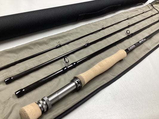 The G. Loomis IMX-PRO V2 Fly Rod 8810-4 8'10" #8, in mint used condition, includes a cork handle, metal reel seat, beige fabric case, and black carrying tube—eligible for our rod and reel trade-in program for store credit.