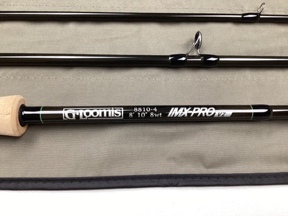 A G. Loomis IMX-PRO V2 Fly Rod 8810-4 8'10" #8 - Used Fly Rod in mint condition is shown on a light gray fabric, ideal for anglers interested in our rod and reel trade-in program.